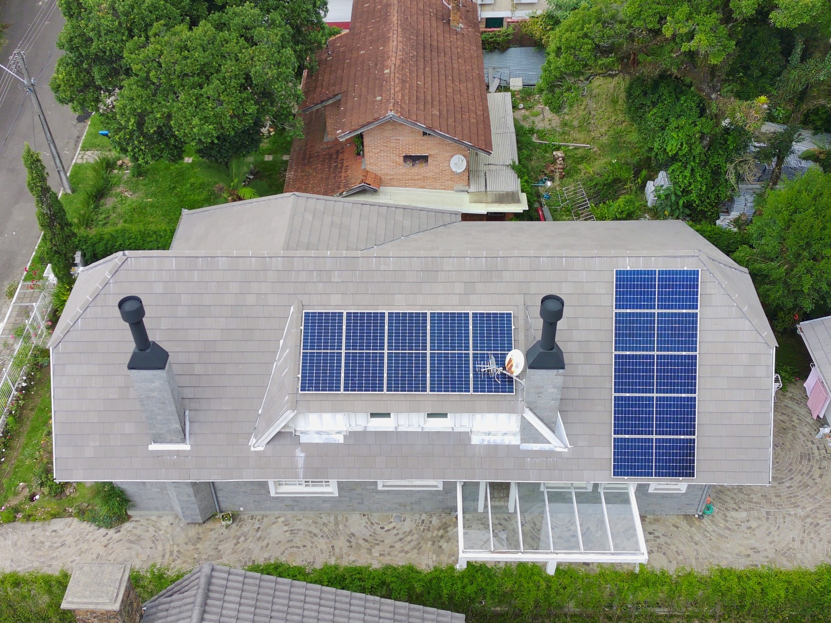 Vista aérea da mesma cobertura residencial com módulos solares instalados